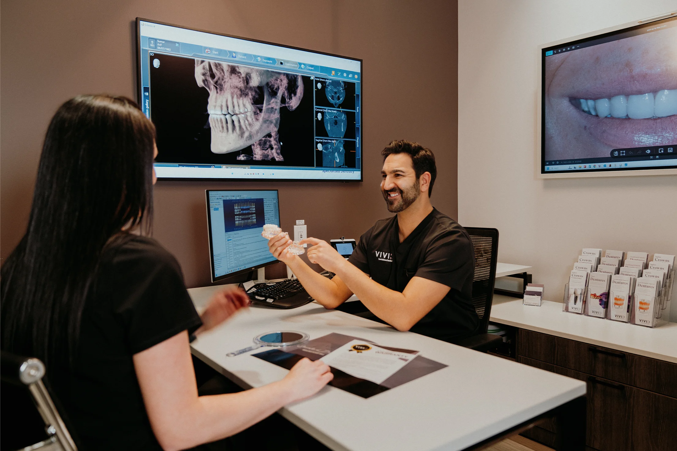Specialist reviewing a 3D CBCT scan of the jaw with a team member at Vivid Specialized Dentistry in Edmonton