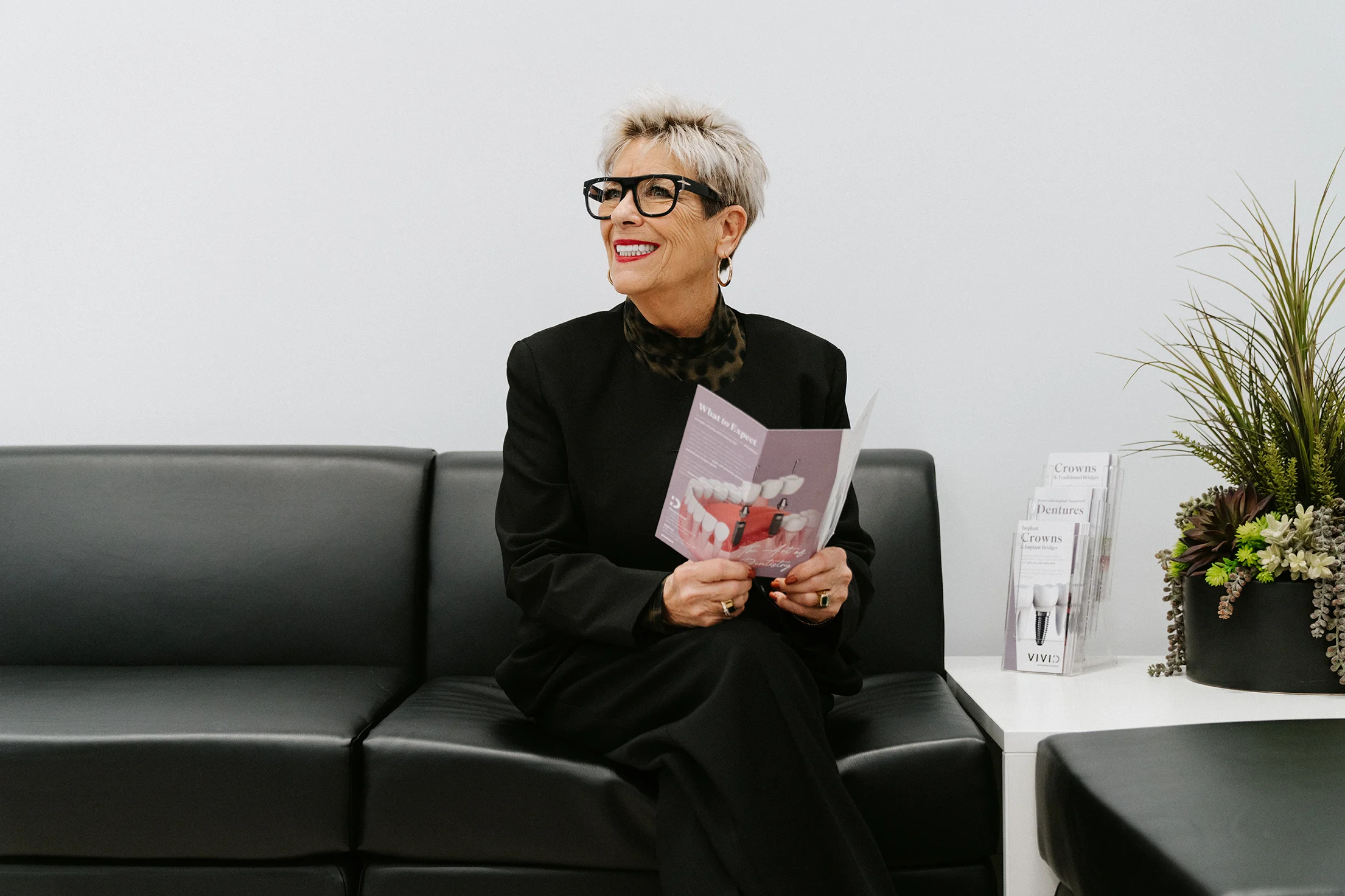 Patient reading a brochure in the Vivid Specialized Dentistry waiting area in Edmonton