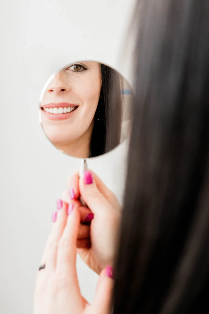 Patient looking her smile on the mirror