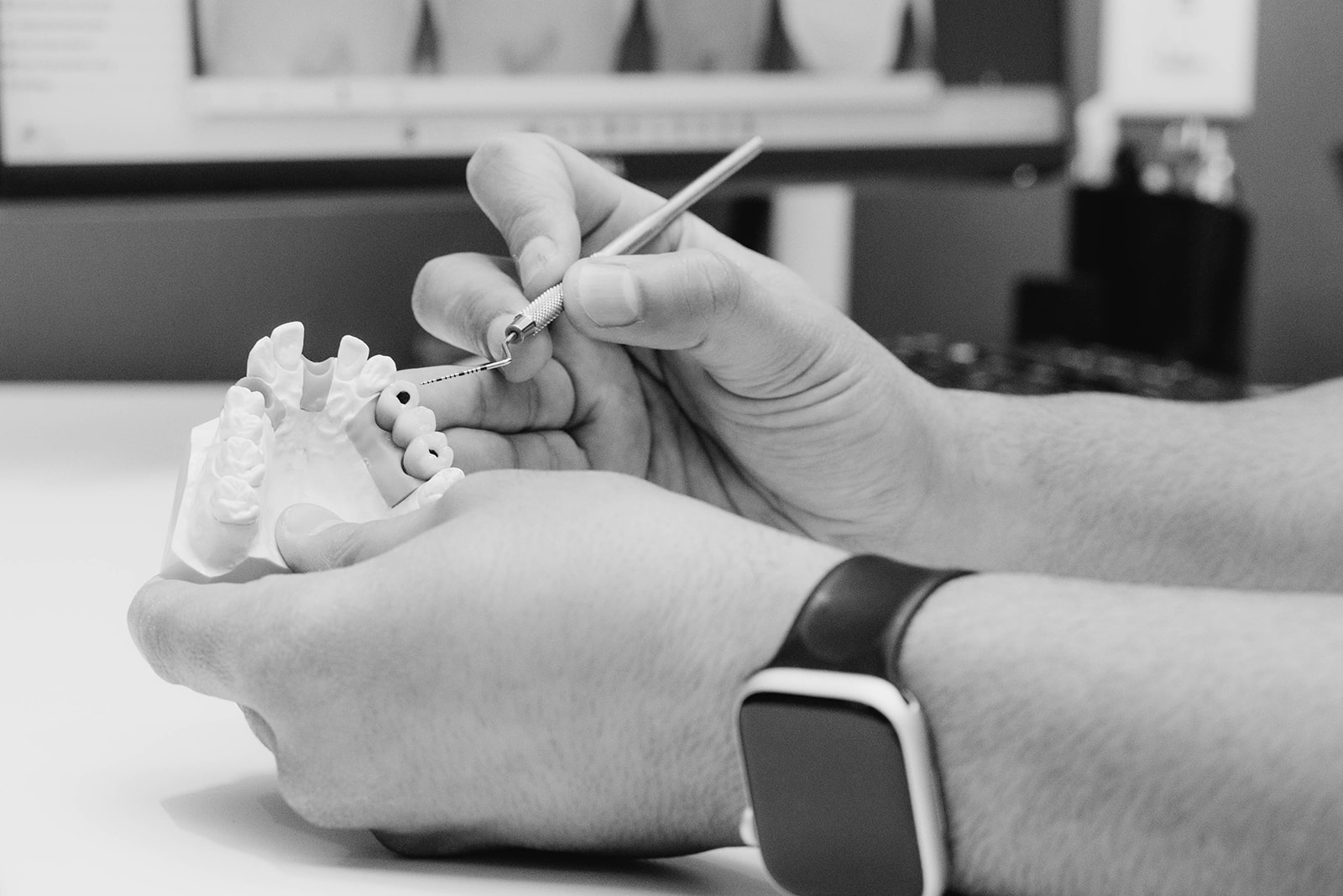 Specialist shaping a dental model by hand while planning treatment